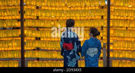 Women in kimono watching lanterns at Yasukuni Shrine during Mitama Matsuri, Tokyo, Japan Stock Photo