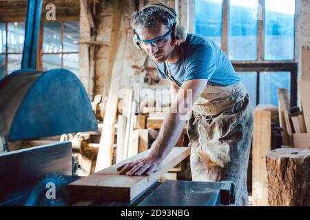 Carpenter working on wood with the circular saw Stock Photo