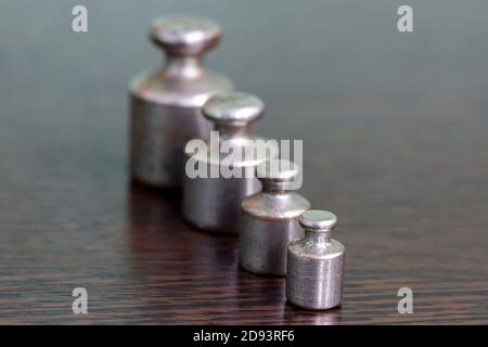 A set of old scratched iron weights for a pharmacy scale. Stock Photo