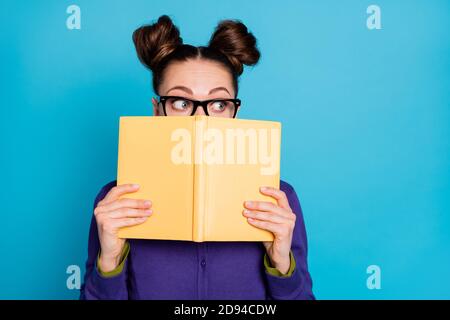 Close-up portrait of her she nice attractive smart clever scared modest schoolgirl hiding behind book task reading isolated on bright vivid shine Stock Photo