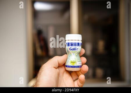 Paris, France - Oct 27, 2020: POV male hand holding one bottle with Gallia infant formula for babies Premium Galliagest Stock Photo