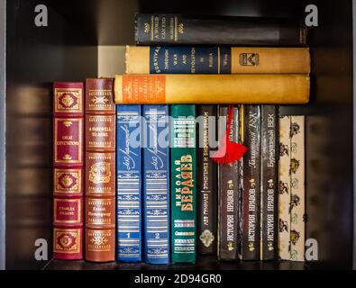 Russian hard cover books in a bookshelf. Stock Photo