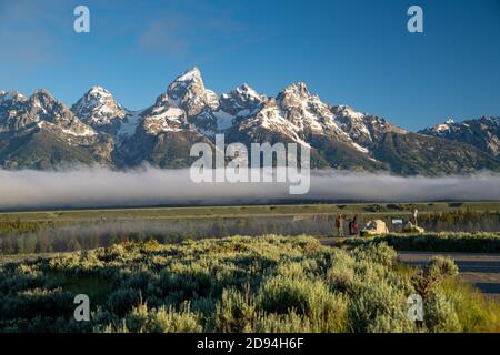 Wyoming, USA - June 26, 2020: Tourists take photos during a morning sunrise with a line of fog in the Grand Teton National Park in summer Stock Photo