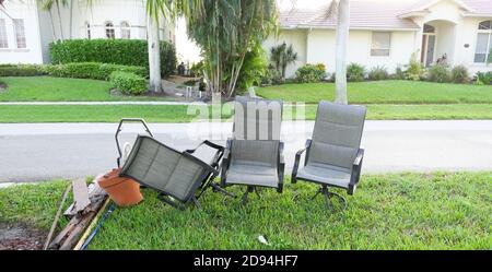 Bulk trash including discarded chairs at curbside for garbage collection. Stock Photo