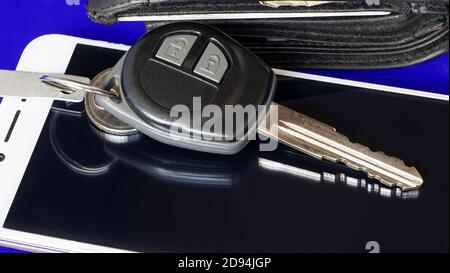 Smartphone and car keys on blue background Stock Photo
