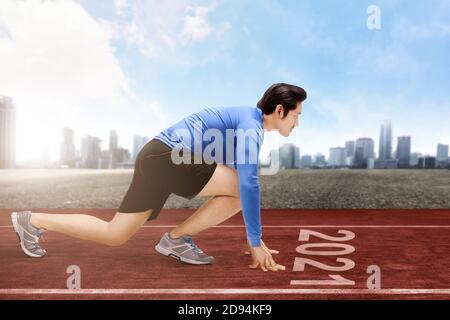Asian runner man ready to run on the 2021 line. Happy New Year 2021 Stock Photo