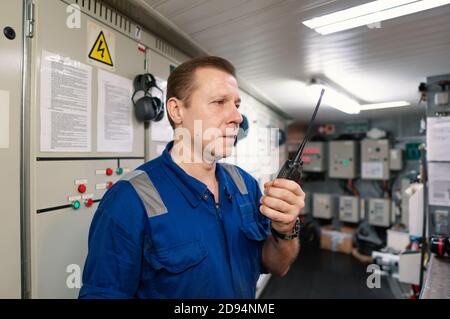 Marine Engineer working on radio communication at Engine Control room ECR Stock Photo