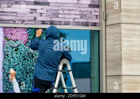 Workers installing window film outdoor. Window foil installation. Stock Photo