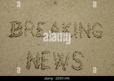 breaking news, sign on the sand beach. word message written on the sand Stock Photo