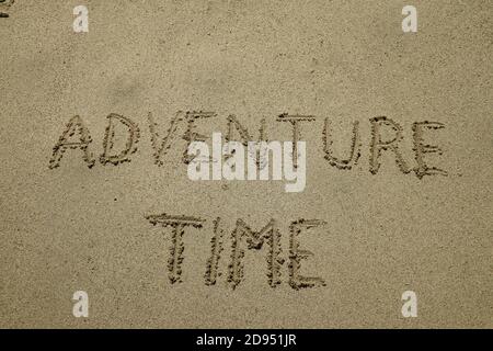 adventure time, happy lifestyle inspirational quote, enjoy the life, text on sand. Say Yes To New Adventures word is written on the beach Stock Photo