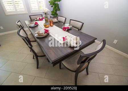 Dining Area With Long Wooden Table With Runner & Place Settings Stock Photo