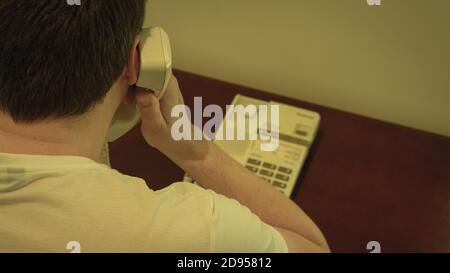 A man talking on a landline phone Stock Photo