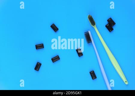 Image of black gum pads with toothbrushes on blue background Stock Photo