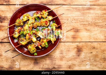 Vegetable kebab from broccoli cabbage on rustic wooden background Stock Photo
