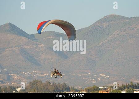 Motorized tandem paraglider, paragliding in front of mountain in southern Spain, Stock Photo