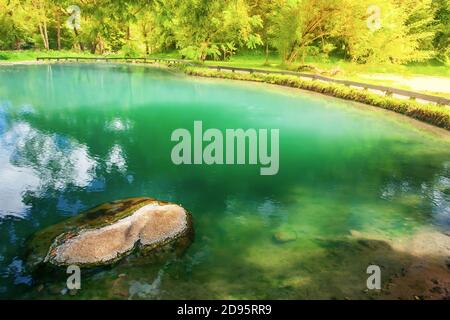 Magical hot pool in a tropical forest, bright and beautiful emerald hot pool at dusk. Focus on the stone on the hot pool. Chiang Rai, Thailand. Stock Photo