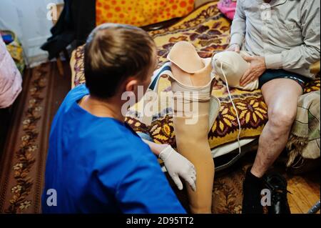 The prosthetist removes the measure from a person with a disability, man with amputee. Stock Photo