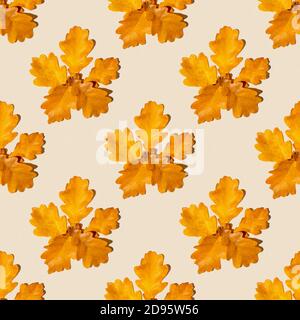 Seamless pattern of dry autumn maple leaves on a light orange background. Autumn print on fabric, wrapping paper Stock Photo