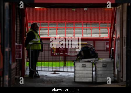 Steward stands by players entrance at empty football stadium ahead of game being played behind closed doors during Covid-19 pandemic in England UK Stock Photo