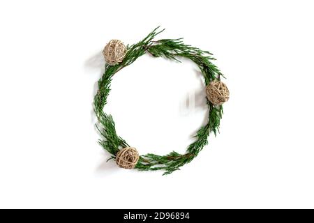 Wreath made from conifer tree branches and rattan balls on a white background Stock Photo