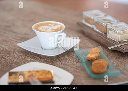 Close-up shot of curd pancakes on plate and cup of coffee on rustic wooden table Stock Photo