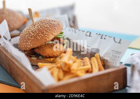 Close-up of beef burger on wooden table background. Hamburger grilled meat burger, lettuce, tomato and fried egg. Gourmet handmade burger Stock Photo