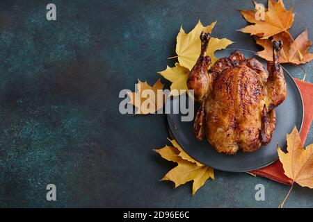 Roasted turkey or chicken dish decorated with autumn maple leaves for Thanksgiving dinner Stock Photo