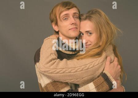 Studio shot of young couple together against gray background Stock Photo