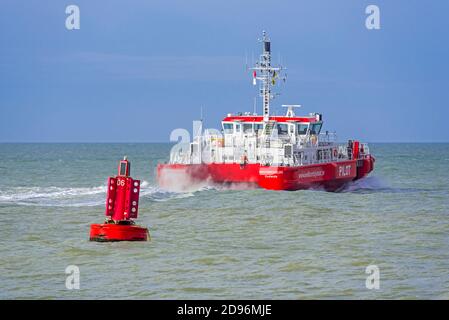 Red buoy in the North Sea and the Westerschelde, Belgian twin-hull pilot vessel leaving the Ostend seaport / Oostende harbour, Flanders, Belgium Stock Photo