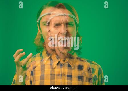 Studio shot of rebellious young man against green background Stock Photo