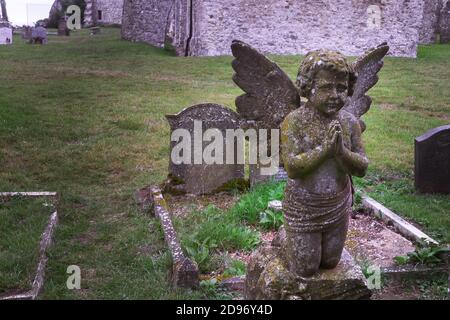 Statue of an angel praying in a cemetery Stock Photo