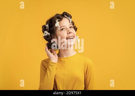 small girl has foil hair curlers. foil hair-curling trick. kid hairdresser salon. healthy long hairstyle. hair care for child. little woman grooming. beauty and fashion. No heat tin foil curls Stock Photo