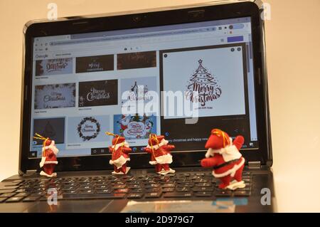 Santa Claus, four Santa Clauses, on top of the keyboard, looking at the laptop screen, looking at the Christmas tree drawings, Brazil, South America Stock Photo