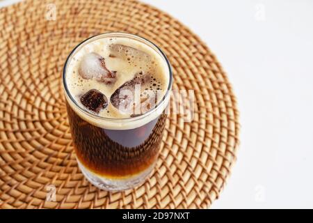Espresso tonic in a glass with ice cubes on the white table Stock Photo