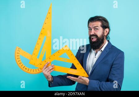 teacher of arithmetic with happy face holding protractor and triangle, learning stem.. Stock Photo