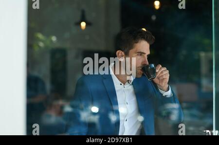 Businessman drinking a cup of coffee inside of a cafe Stock Photo