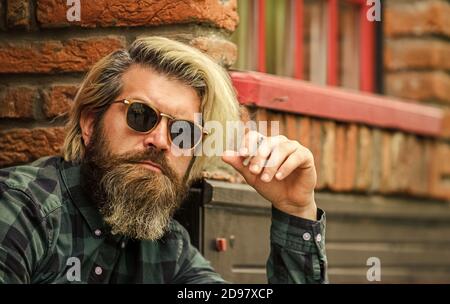 Smoking habit. Man with cigarette. Cool guy relaxing. Reduce stress. Mental  health. Hipster smoking old architecture background. Medical cannabis. Guy  in sunglasses smoking tobacco. Smoking outdoors Stock Photo