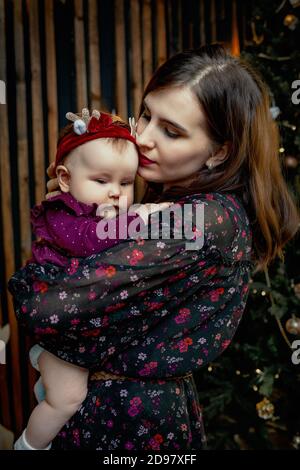 Young beautiful girl holding her little daughter in her arms Stock Photo