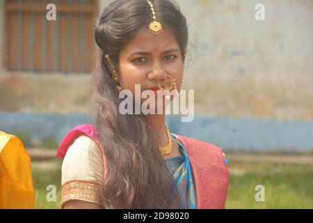 Close up of a teenage Indian girls wearing sari and golden nose ring maang tikka necklace earrings bangles with make up sitting on a field Stock Photo - Alamy Close up of a teenage Indian girls wearing sari and golden nose ring maang tikka necklace earrings bangles with make up sitting on a field Stock Photo - Alamy
