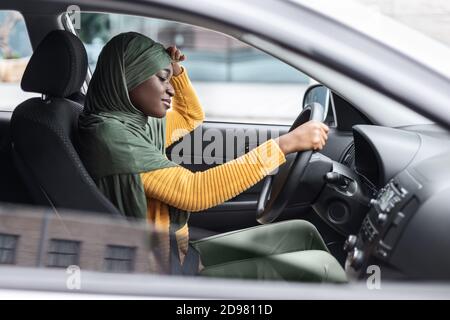 Tired African Muslim Lady Driving Car, Having Headache And Feeling Sleepy Stock Photo