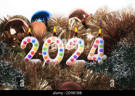 Four colorful candles write numbers flame Happy new year 2024 Stock Photo