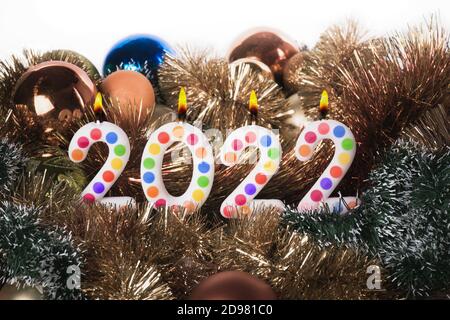 Four colorful candles write numbers flame Happy new year 2022