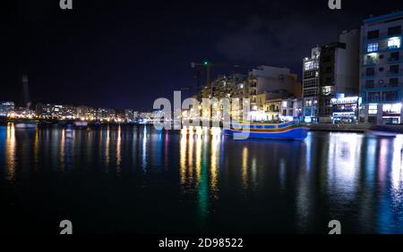 ST. JULIAN'S - MALTA, 29 March 2017: Lights and reflections in Spinola Bay at night. Saint Julian's is a town in the Central Region of Malta and situa Stock Photo