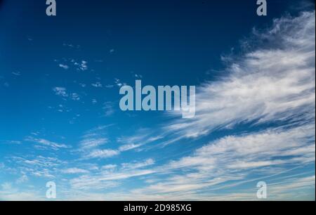 frayed cirrus clouds on deep blue sky Stock Photo