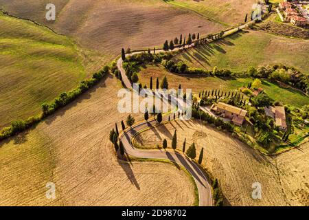 Aerial view of winding road and golden farm fields in Pienza Tuscany Italy. Stock Photo