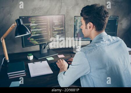 Rear back behind view portrait of his he nice attractive focused geek guy typing css analyzing cyberspace security building at modern industrial Stock Photo