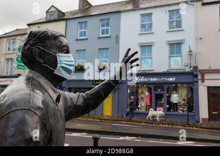 Listowel, Ireland - 24th October 2020:  Statue of the late writer and playwright  John B Keane with medical facemask in the town of Listowel during co Stock Photo