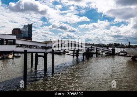 Hamburg, Germany - August 16, 2019: Bridge in the pier on the Elbe river with the Elbphilharmonie (Elbe Philharmonic Hall) in the background in St Pau Stock Photo