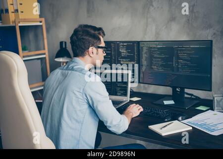 Profile side view portrait of his he nice focused geek guy tech specialist checking database creating code source implementation at modern industrial Stock Photo