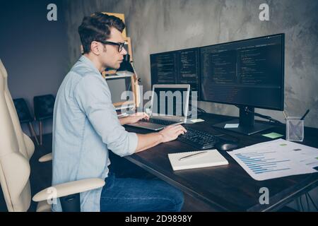 Profile side view portrait of his he nice skilled expert geek guy specialist solving problem remote 24 on 7 tech support dev ops at modern industrial Stock Photo